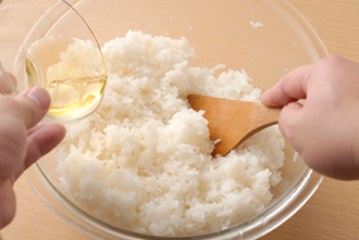 ご飯をボウルに入れてすし酢をかけ、きるようにして手早く混ぜてすし飯を作る。