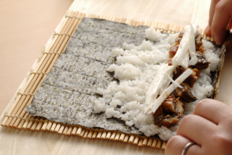 まきすにのりをのせ、奥の1/3くらいを残して、すし飯をしく。手前にうなぎ、山芋を並べ、まきすでぐるりと巻きこむ。食べやすい大きさに切って器に盛り、しょうがの甘酢漬けを添える。巻き寿司を切るときは、１回切るごとに包丁の刃に酢をつけるようにすると切りやすい。