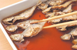 バットに南蛮酢の材料と赤唐辛子を入れて混ぜ合わせる。小あじが揚げ上がったら取り出し、南蛮酢に漬け、玉ねぎ、にんじんも一緒によくからめ、ラップをかけて30分以上（できれば半日～1日）おく。