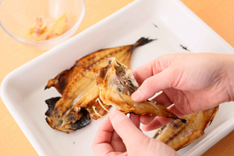 あじの干物はグリルでこんがりと焼き、粗熱がとれたら骨と皮をはずして身をほぐす。トマトはへたを取って1センチ角に切る。