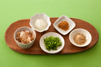 薬味の準備をする。大根おろし、万能ねぎ、削り節、七味唐辛子、白すりごまを器に盛る。具が温まったら器に取って好みの薬味をのせ、めんつゆまたはポン酢じょうゆをかけて食べる。