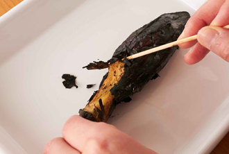 熱いうちになすの皮をむく。へたの方から、竹串をかるく刺して皮を持ち上げるようにするとよい。