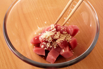まぐろを角切りにしてボウルに入れ、ごま油、しょうゆ、にんにくを加えてあえる。万能ねぎは小口切りにする。