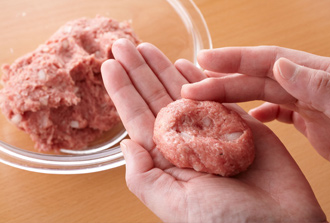 玉ねぎはみじん切りに、ねぎは粗みじんに切る。なすはひと口大の乱切りにする。パン粉を牛乳でしめらせておく。ボウルにひき肉、塩、黒こしょう少々を入れ、粘りが出るまでよく練る。玉ねぎ、卵、パン粉を入れ、さらに練る。ひと口大の楕円形にまとめ、真ん中を少しくぼませる。別のボウルにトマトの水煮を入れ、果肉はつぶす。ねぎのみじん切り、Aを加えてよく混ぜ、トマトソースを作っておく。