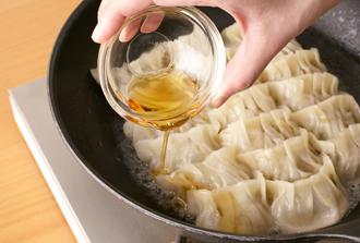 フライパンにサラダ油を入れて中火にかけ、餃子を並べる。熱湯3/4カップ（分量外）を注ぎ入れ、ふたをする。水気がほとんどなくなったらふたを外し、ごま油を回しかける。こんがりと焼き目がついたらでき上がり。好みで酢じょうゆなどをつけて食べる。