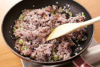 フライパンにベーコンを入れて炒める。焼き色がついたらねぎを加えて炒め、黒豆五穀ごはんを茶碗2杯分加える。全体を炒め合わせたら塩少々、こしょう、しょうゆで味を調える。