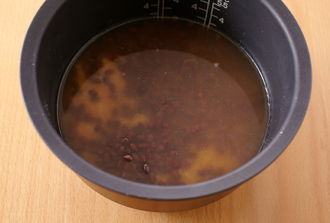 もち米を炊飯器に入れる。こし器（またはざる）をのせ、1の鍋をあけてゆで汁だけ炊飯器に加える。炊飯器の目盛りを参照し、「おこわ」の2のラインまで水を足し、砂糖、塩を加えて混ぜる。汁気をきった小豆をのせ、おこわ炊きコースで炊く。※炊飯器におこわ炊き機能がない場合は、小豆のゆで汁と水を合わせて340mlを注いで通常通りに炊いてください。