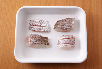 鯛に骨があれば取り除き、半分に切る。皮目に2本かるく切り込みを入れ、塩と酒をふって10分おく。4等分に丸く握った赤飯を耐熱の器にのせ、それぞれの赤飯の上に水気を拭いた鯛をのせて、蒸気の上がった蒸し器で8分蒸す。ゆず果汁をかるくふり、せん切りにしたゆずの皮、三つ葉を添える。