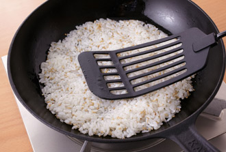ボウルにご飯、白いりごま、ごま油を入れてよく混ぜ、熱したフライパンに丸く広げる。平らになるよう、フライ返しなどで押さえつけながら焼き色がつくまで焼く。