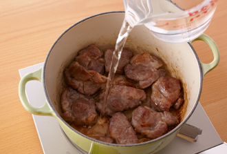 厚手の鍋にサラダ油を中火で熱し、ゆでた豚肉を入れて三温糖をふってからめ、ころがしながら1分ほど全体を焼きつける。Aを加え、ペーパータオルで落としぶたをして弱めの中火で60分くらい煮る。