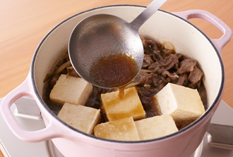 肉の色が半分くらい変わったらAを加える。煮立ったらアクを取り、豆腐を加えてときどき煮汁を回しかけながら2～3分煮て火を止める。粗熱がとれたら器に盛り、万能ねぎをのせる。