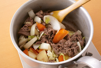 鍋にバターとオリーブ油を入れて中火で熱し、牛肉を炒める。肉の色が変わったらにんにく、じゃがいも、にんじん、キャベツ、玉ねぎを加え、全体に油がなじむまで炒める。