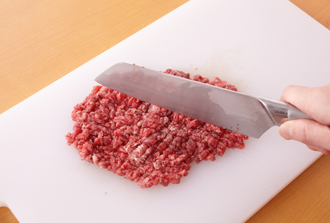 牛肉を包丁でおおまかに切った後、包丁でたたいて粗いミンチ状にする。