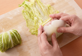 白菜を4等分に分け、少しずつずらして重ねる。ひき肉だねの1/4量を手前に置き、くるくると巻く。巻き終わりを下にして鍋に並べ、にんじんも加える。スープを注いで中火にかけ、沸騰したら弱めの中火にし、ふたをして10分煮る。