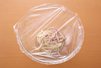 玉ねぎは薄切り、ベーコンは細切りにする。耐熱のボウルに玉ねぎ、ベーコン、オリーブ油を入れて混ぜ合わせ、ラップをかけて電子レンジ（600W）で3分加熱する。
