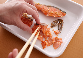 炊きあがったら鮭を取り出して皮と骨を取り除き、粗くほぐしてご飯に混ぜる。器に盛り、いくら、しそを散らす。