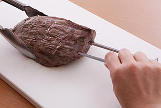 牛肉を魚焼きグリルに入れ、ときどき面を変えながら強火で全体をこんがり焼いて取り出す。粗熱がとれたら金串を刺して、焼けた表面をそぎ切りにし、食べたい分を皿に取り分けて野菜ソースを添える。牛肉が赤身だけになったらもう一度グリルで焼きましょう。