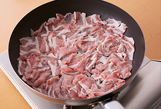 火をつける前にフライパンにサラダ油を入れ、豚肉を広げながら並べる。中火にかけて焼く。