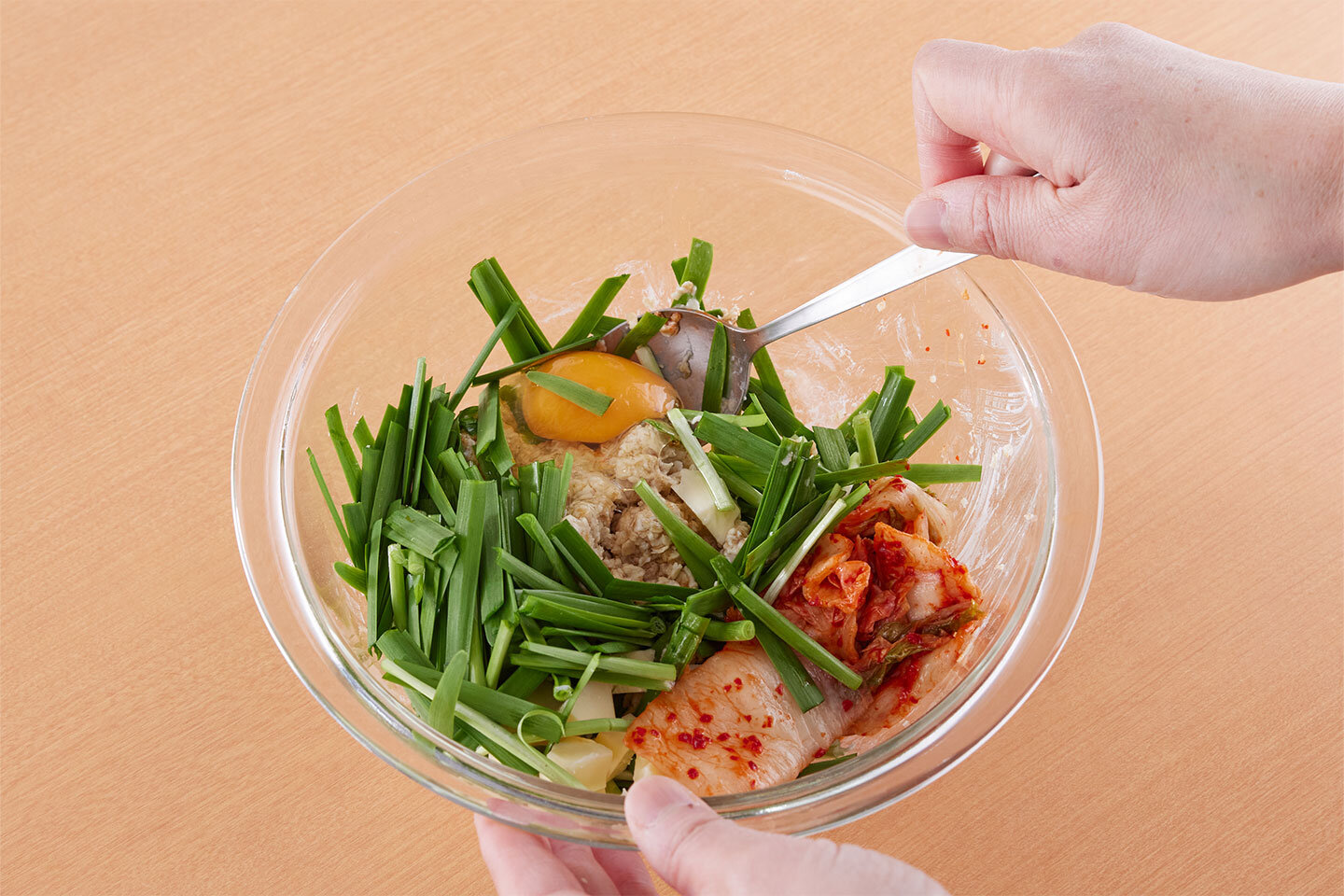 ニラは長さ4センチに切る。チーズは手で細かくちぎる。白菜キムチは食べやすく切る。1のボウルにニラ、チーズ、キムチを加え、卵を割り入れて混ぜ合わせる。