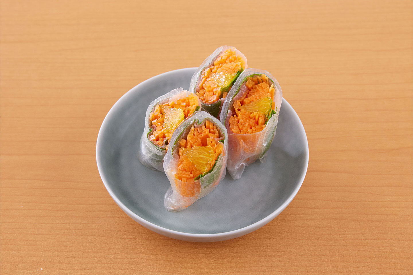 中に入れる具を変えると、味も見た目もガラリと印象が変わります。せん切りにしたにんじん、生ハム4枚、房から取り出したオレンジの果肉適量を、フレッシュミントやバジルとともに包むと華やかに！