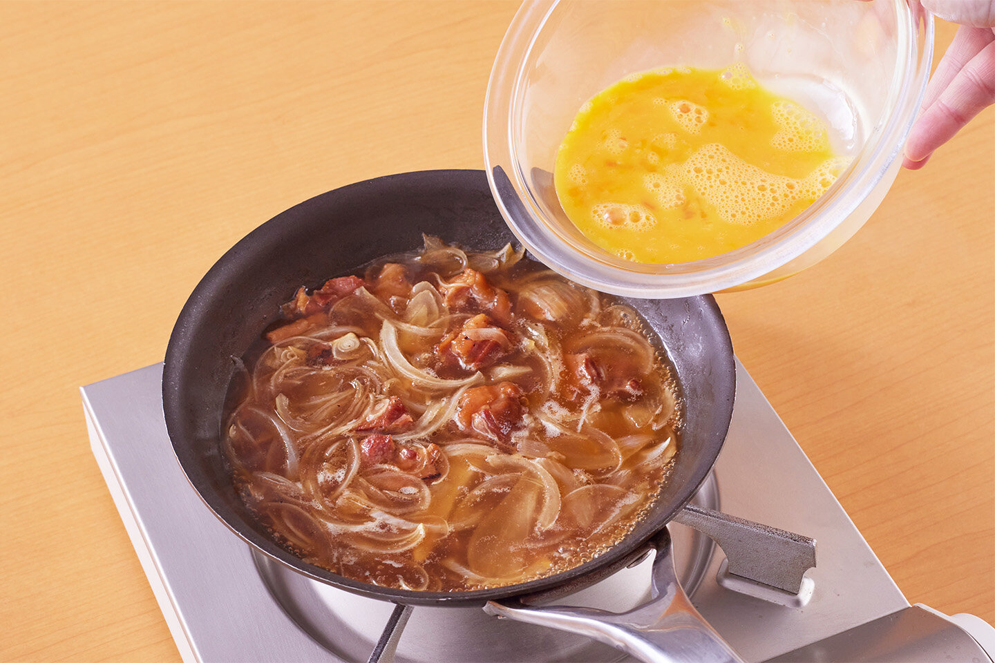 小さめのフライパンに焼き鳥を缶汁ごと入れる。<br>A、玉ねぎを加えて中火にかけ、5分ほど煮る。強火にし、卵を溶きほぐして回し入れ、ピザ用チーズも加えて箸で大きく3〜4回ほど混ぜ、そのまま1分ほど煮る。<br>三つ葉をのせ、ふたをして2〜3分ほどおく。